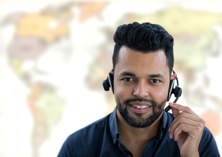 Digital composite of Travel agent man wearing headset in front of world mapの写真素材