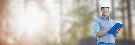 Digital composite of Construction Worker on building site holding chart plans