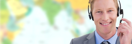 Digital composite of Travel agent man wearing headset in front of world mapの写真素材