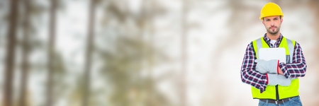 Digital composite of Construction Worker holding papers by trees
