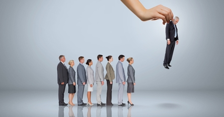 Digital composite of hand choosing a business man on grey background with business peopleの写真素材