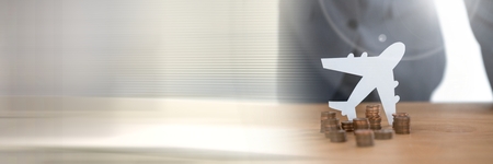 Digital composite of Paper Cut Out plane over money coinsの写真素材