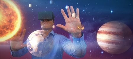 Smiling businessman sitting chair while wearing vr glasses against pink and purple background