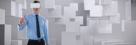 Young businessman gesturing using wearable computer against abstract white roomの写真素材