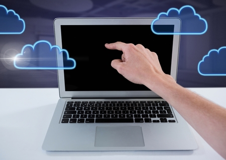 Digital composite of Hand using laptop with cloud icons