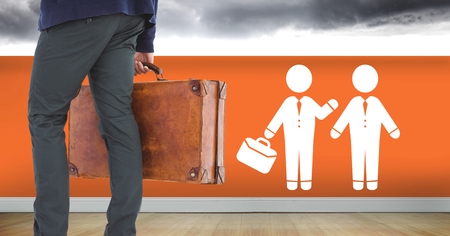 Digital composite of Businessman with briefcase and people meeting icon on wallの写真素材