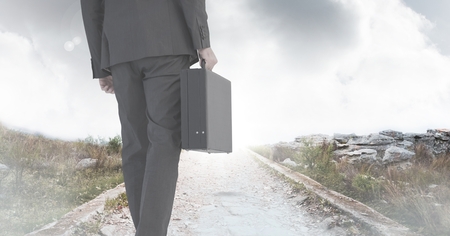 Digital composite of Businessman holding briefcase on pathの写真素材
