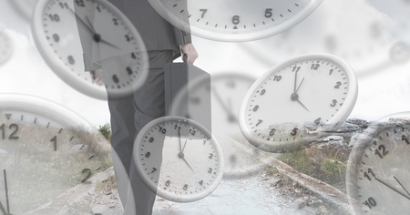 Digital composite of Businessman holding briefcase with surreal clocks time transitionの写真素材