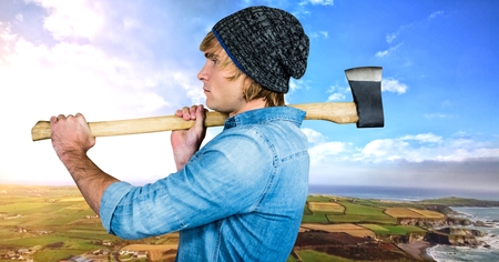 Digital composite of Man holding axe with dramatic landscapeの写真素材