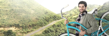 Digital composite of Travelling man with bicycle in front of landscape terrainの写真素材