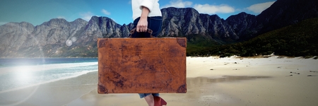 Digital composite of Travelling woman with bag in front of beach landscapeの写真素材