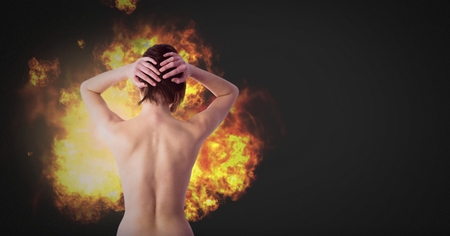 Digital composite of Nude dramatic woman with burning fire flamesの写真素材