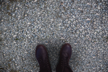 Close-up of black boots against concrete floorの写真素材