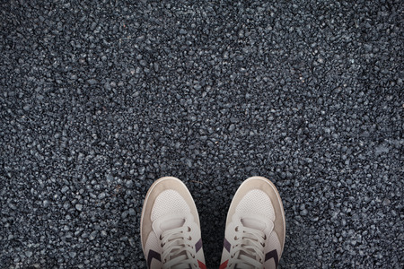 Focus of sport-wear shoes  against black roadの写真素材