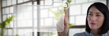 Woman using invisible screen against a line of green plantsの写真素材
