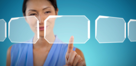 Close up of smiling businesswoman touching interface against abstract blue backgroundの写真素材