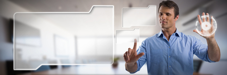 Male executive pressing an invisible virtual screen against empty modern meeting roomの写真素材