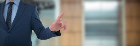 Mid section of businessman selecting on imaginary screen against lift in office buildingの写真素材