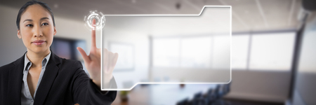 Businesswoman pressing an invisible virtual screen against interior of empty modern meeting roomの写真素材