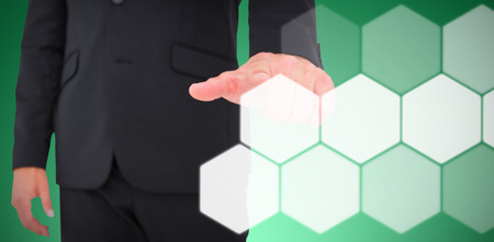 Businessman pointing with finger against abstract green backgroundの写真素材