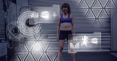 Digital composite of athletic fit woman in gym with health interfaceの写真素材