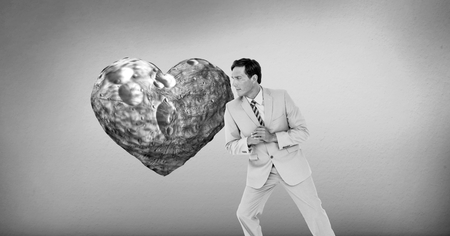 Digital composite of businessman leaning against surreal heartの写真素材