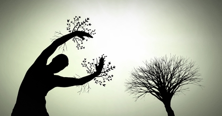 Digital composite of person reaching with surreal tree branches silhouetteの写真素材