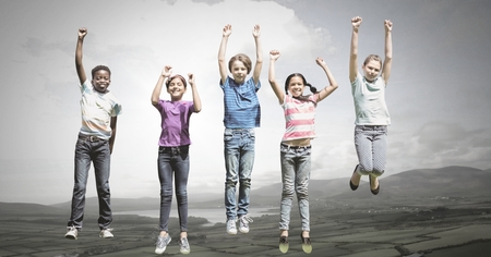 Digital composite of children jumping for joy into sky with natural landscapeの写真素材
