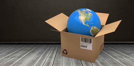 Computer graphic 3D image of globe in cardboard box against dark roomの写真素材