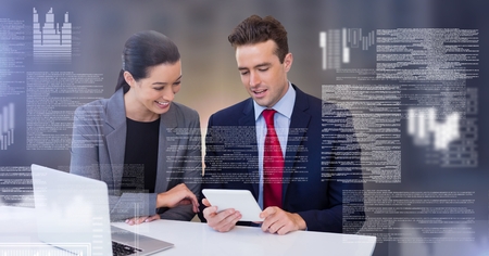 Digital composite of Business couple working on laptop with screen text interface