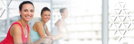 Digital composite of Athletic fit women in gym with triangle interfaceの写真素材