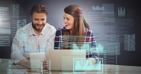 Digital composite of Business couple working on laptop with screen text interface