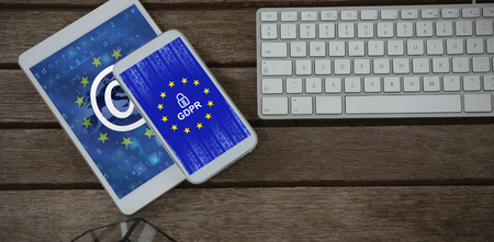 Digital tablet, mobile phone, pot plant and keyboard on wooden plank against european union flag with binary codes and @ signの写真素材