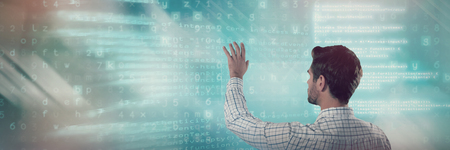 Man pretending to touch an invisible screen against blue codeの写真素材