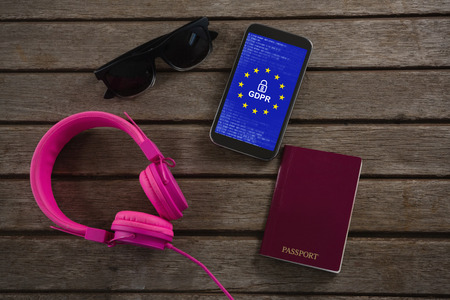 Headphones, sunglasses, passport and mobile phone wooden plank against european union lockedの写真素材