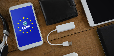 Various electronic gadgets on wooden plank against european union locked