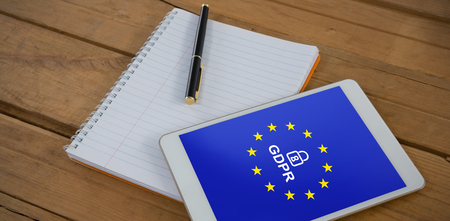 Blank notepad and digital tablet on wooden plank against europe locked gdprの写真素材