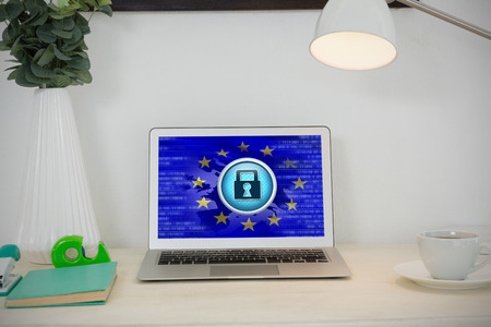 Laptop and various office accessories on table against european union flag with safety concept