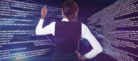 Rear view of businesswoman with hand on hip using invisible interface against volume knob interfaceの写真素材