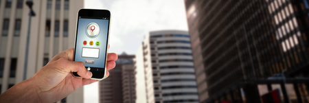 Cropped image of person holding mobile phone against view of modern office building