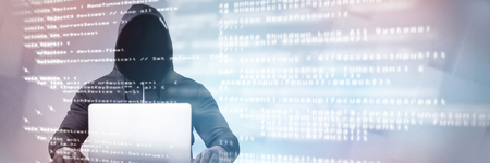 Male hacker with laptop on table  against blue codeの写真素材