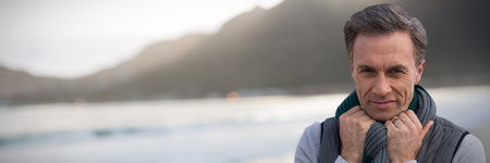 Portrait of handsome mature man  against mountain against sky at beachの写真素材