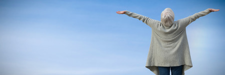 Elder woman stretching  against view of blue sky and cloud