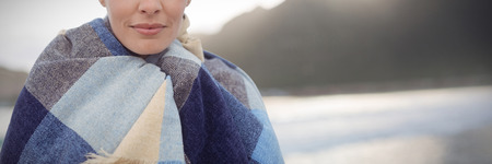 Portrait of brunette women wearing scarf against mountain against sky at beach