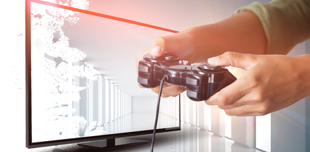 Woman playing video game against white background against digitally generated room with bright lightの写真素材