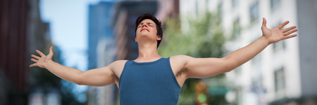 Man with arms outstretched over white background against blur view of a modern city