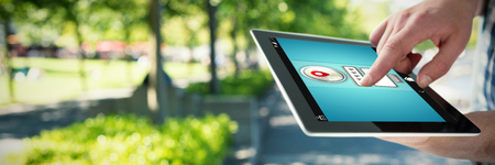Cropped hands of man using digital tablet against blur view of park