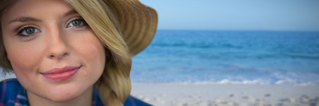 Close up portrait of smiling young blonde woman against beach against clear skyの写真素材
