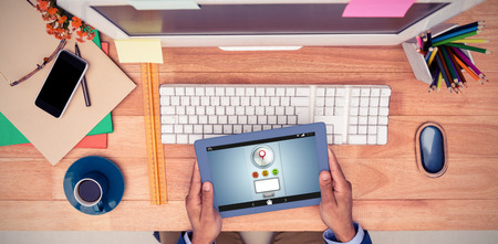 Screenshot of a rating service  against businessman holding digital tablet while sitting at computer deskの写真素材