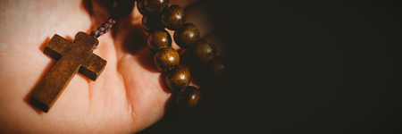 Close-up of hand holding rosary beads